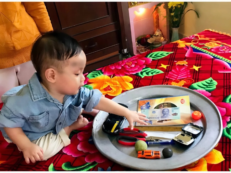 Bé bốc đồ vật ngày thôi nôi